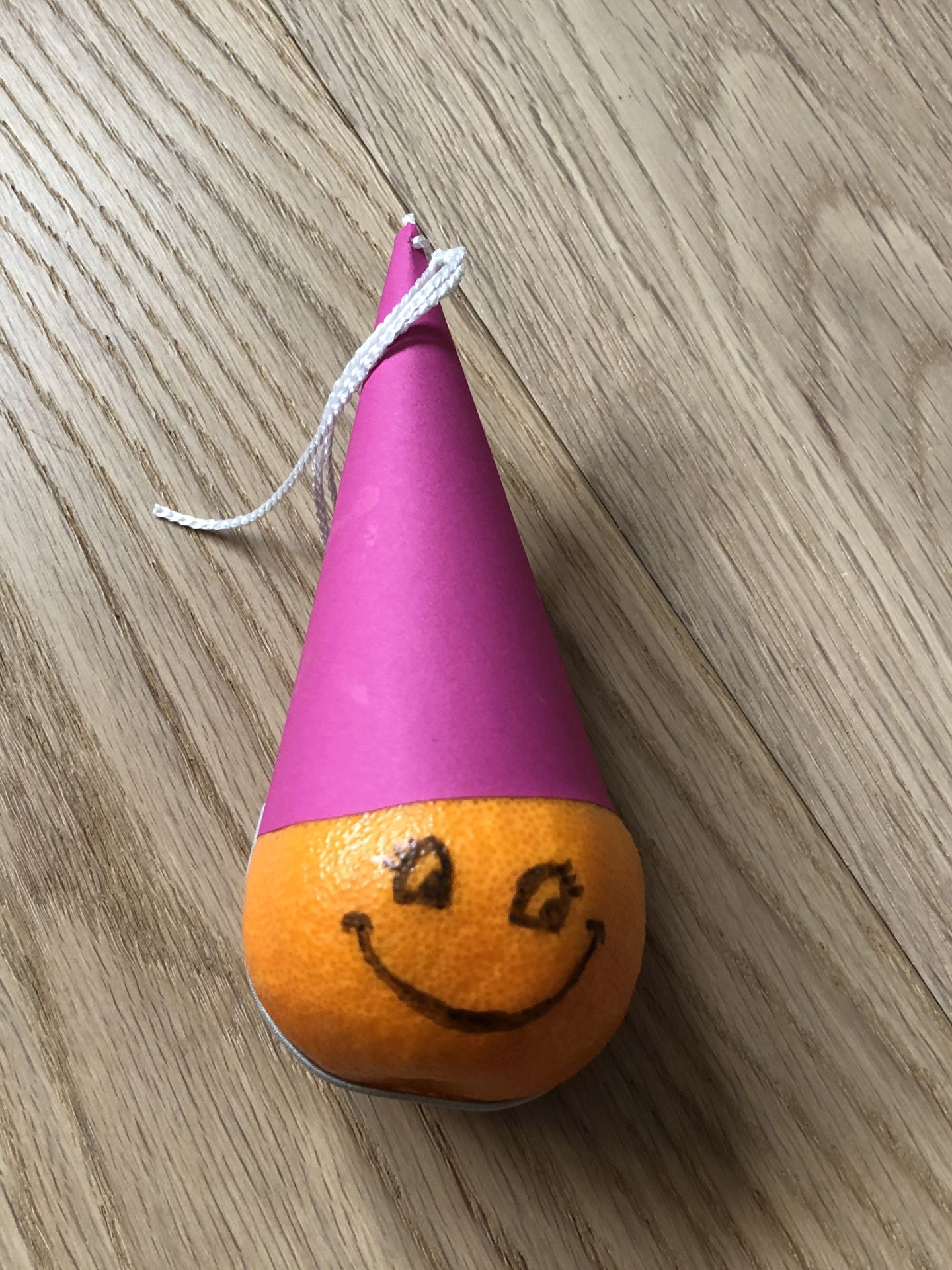 Mandarine mit Partyhut und Gesicht